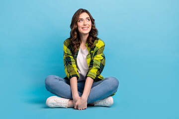 Sticker - Full body photo of nice cheerful minded lady sit floor look interested empty space isolated on blue color background