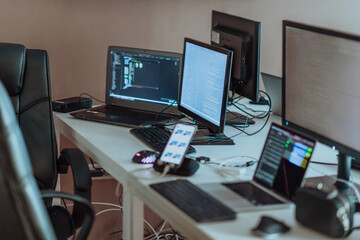 Computer screens running programming code in empty software developing agency office and computers parsing data algorithms in background. Neural network servers cloud computing in data room.