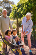 © Monkey Business - Grandchildren Pushed In Barrow By Grandparents Working In Vegetable Garden Or Allotment
