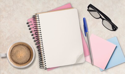 Blank notepads, glasses, sticky note and coffee on desk