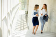 © BGStock72 - Two young business women walking on stairs in the office hallway