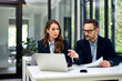© bnenin - Serious adult businesspeople working on a laptop at the office table.