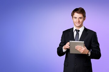 Cheerful young businessman holding digital tablet computer