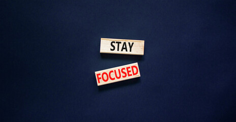 Stay focused symbol. Concept words Stay focused on wooden blocks on a beautiful black table black background. Business, support, motivation, psychological and stay focused concept. Copy space.