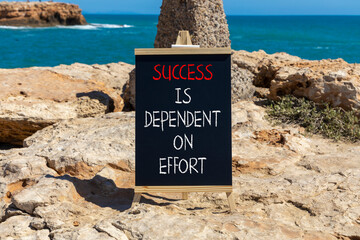 Wall Mural - Success and effort symbol. Concept words Success is dependent on effort on beautiful black chalkboard. Beautiful stone sea background. Business success and effort concept. Copy space.