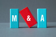 M and A - Mergers and Acquisitions, word concept on building blocks, text