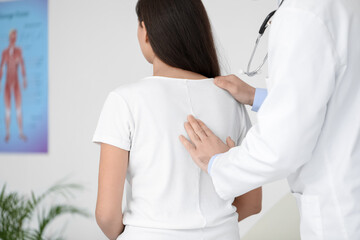 Poster - Male doctor checking posture of young woman in clinic