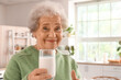 © Pixel-Shot - Senior woman with glass of milk in kitchen, closeup