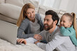 © New Africa - Happy family with laptop on floor at home