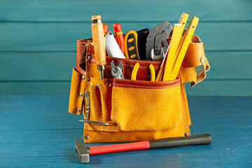 Canvas Print - Belt with different tools on blue wooden table