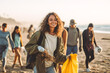 © MVProductions - Young woman picking up trash with group of volunteers and activists on the beach. Generative AI