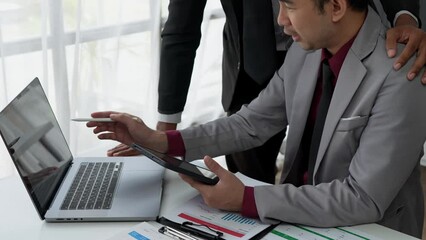 Asian businessmen and investors brainstorm applications for web design planning and develop templates, graphs, and calculations for mobile projects working together in the office.	
