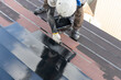 屋根トタンの塗装をする職人