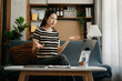 © Nuttapong punna - Working woman concept a female manager attending video conference and holding tablet, smatrphone on sofa in living room at home..