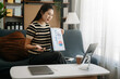 © Nuttapong punna - Working woman concept a female manager attending video conference and holding tablet, smatrphone on sofa in living room at home..