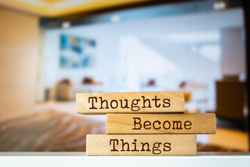 Wooden blocks with words 'Thoughts Become Things'.