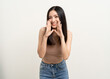 © Chanakon - Happy beautiful asian woman with copy space. Excited pretty girl shout out loud wow with hands on mouth announcement standing pose on isolated white background.