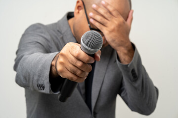 Canvas Print - Businessman speaker with high quality dynamic microphone speaking talking with people on isolated white background. Male testing microphone voice for interview. Motivation life coach in training