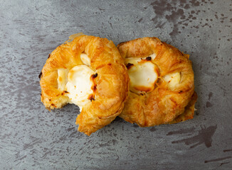 Wall Mural - Top view of two delicious cream cheese danishes with one missing a bite on a gray mottled tabletop.