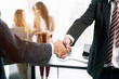 © NINENII - Business people shaking hands, finishing up a meeting.
