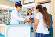 © CandyRetriever  - Medical pharmacy and healthcare providers concept. Professional Asian man and woman pharmacist recommend and selling medical product, medicine, drugs and supplements to patient customer in drugstore.