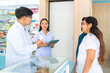 © CandyRetriever  - Medical pharmacy and healthcare providers concept. Professional Asian man and woman pharmacist recommend and selling medical product, medicine, drugs and supplements to patient customer in drugstore.