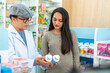 © CandyRetriever  - Medical pharmacy and healthcare business concept. Asian man pharmacist medication recommendation medical product, drugs, medicine, and supplements to woman patient customer in modern drugstore.