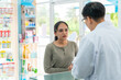© CandyRetriever  - Asian man pharmacist medication recommendation about medicine, drugs and supplements to woman patient with stomach ache customer in drugstore. Medical pharmacy and healthcare providers concept.