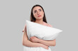 © New Africa - Tired young woman with pillow on light grey background. Insomnia problem