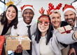 © Samir H/peopleimages.com - Friends, selfie and business people at christmas party in the office with silly accessories. Diversity, smile and happy corporate colleagues taking picture together with gifts at festive celebration.