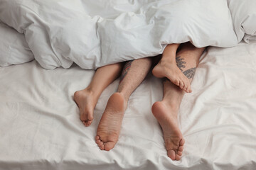 Wall Mural - passionate couple having sex on bed, closeup of legs