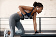 Fitness, dumbbell and female athlete doing a exercise in gym for strength, arm and body training. Sports, challenge and black woman doing muscle workout with weights for motivation in sport center.