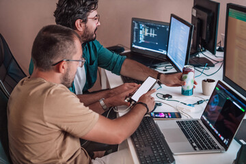Programmers engrossed in deep collaboration, diligently working together to solve complex problems and develop innovative mobile applications with seamless functionality.