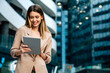 © NDABCREATIVITY - Portrait of successful woman using digital tablet in urban background. Business people concept