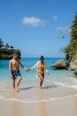 Wall Mural - A couple of men and women in swimshorts and bikinis at Playa Lagun Beach Cliff Curacao, Lagun Beach Curacao a small island in the Caribbean. 