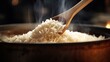 rice being scooped from a steaming pot with a wooden spoon