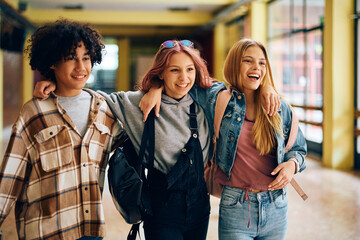 Wall Mural - Embraced high school students have fun while walking through hallway.