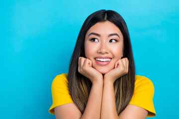 Wall Mural - Portrait of good mood woman with dyed hairstyle wear stylish t-shirt hands under chin look empty space isolated on blue color background