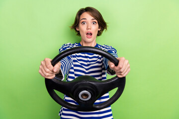 Sticker - Photo of funny excited shocked girl wear striped t-shirt hold steering wheel unexpected car crash accident isolated on green background