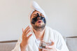funny bearded man applying black mask for skin care