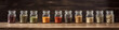© PaulShlykov - Glass jars with different spices in row on kitchen worktop closeup Generative AI