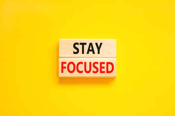 Stay focused symbol. Concept words Stay focused on wooden blocks on a beautiful yellow table yellow background. Business, support, motivation, psychological and stay focused concept. Copy space.