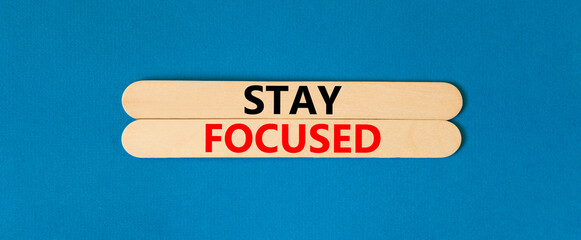 Stay focused symbol. Concept words Stay focused on beautiful wooden stick on a beautiful blue table blue background. Business, support, motivation, psychological and stay focused concept. Copy space.