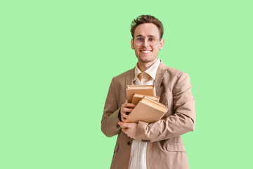 Wall Mural - Young man with books on green background