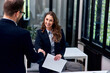© bnenin - A smiling woman handshake with a businessman on a job interview.