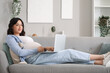 © Pixel-Shot - Young pregnant woman working with laptop on sofa at home
