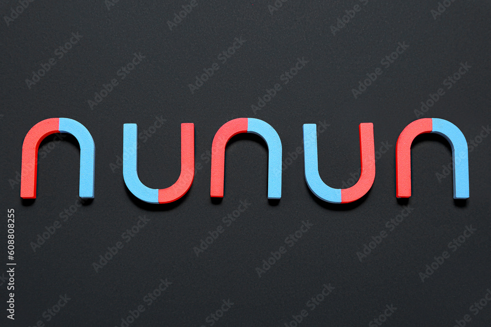 Horseshoe shaped magnets on black background