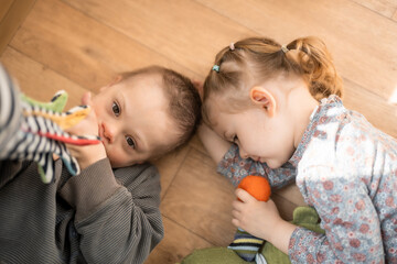 Wall Mural - Boy with Down syndrome and ASD plays with his younger sister in home bedroom