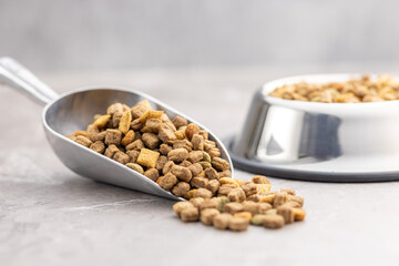 Poster - Dry kibble pet food. Dog or cat food in scoop on gray table.