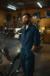 © Nomad_Soul - Portrait of handsome serious repairman wearing overalls standing in workshop